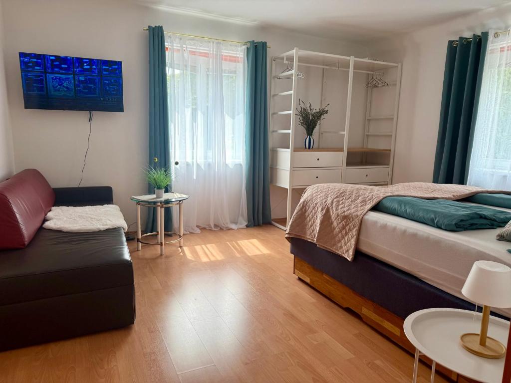 Schlafzimmer mit TV und Sofa Apartment D01